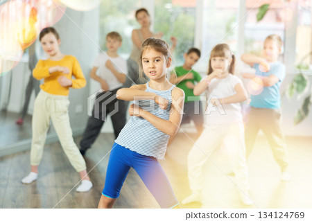 Girl learn to dance modern dances, doing movement with unrecognizable teacher. Girl learn to dance modern dances, doing movement with unrecognizable teacher. 134124769