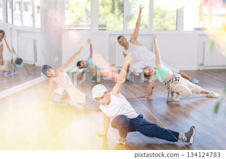 Preteen boys and girls studying movement of contemporary dance in classroom with his friends Preteen boys and girls studying movement of contemporary dance in classroom with his friends 134124783
