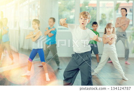 Boy learn to dance modern dances, repeat movement with unrecognizable teacher. Boy learn to dance modern dances, repeat movement with unrecognizable teacher. 134124787