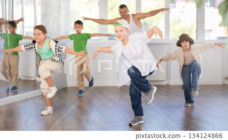 Girls and boys performing hip hop dance training hall during group dancing classes Girls and boys performing hip hop dance training hall during group dancing classes 134124866