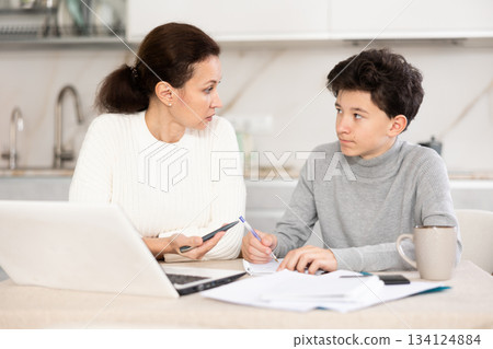Boy and mother studiyng together 134124884