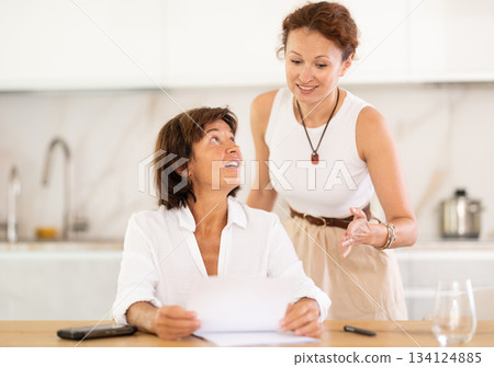 Woman helps her girlfriend sort out documents and financial problems 134124885