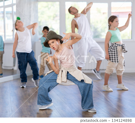 Preteen girl practicing hip hop choreography with peers and instructor Preteen girl practicing hip hop choreography with peers and instructor 134124898