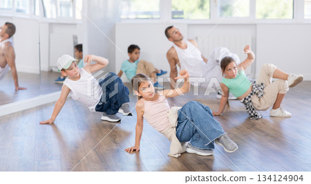 Preteen boys and girls studying movement of contemporary dance in classroom with his friends 134124904