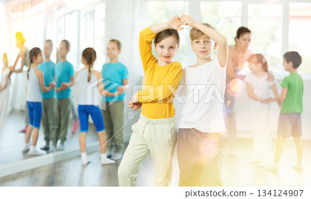 Girl paired up with boy and training to perform slow couple dance, rehearse performance. 134124907