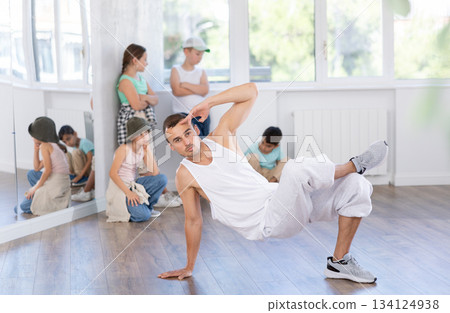 Dance teacher showing kids how to low break dance in studio 134124938