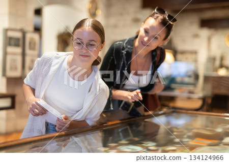 Woman and teenage girl looking at exhibit in museum display 134124966