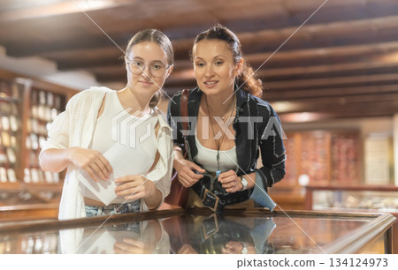 Woman and teenage girl looking at exhibit in museum display Woman and teenage girl looking at exhibit in museum display 134124973