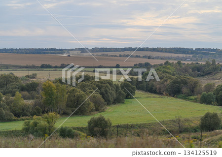 A Beautiful, Serene Green Landscape Showcasing Rolling Hills Beneath an Overcast Sky A Beautiful, Serene Green Landscape Showcasing Rolling Hills Beneath an Overcast Sky 134125519