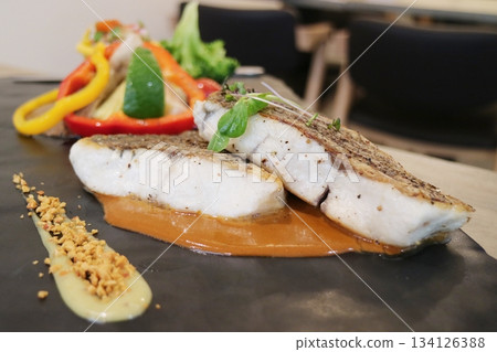 Pan-fried sea bass with vegetables 134126388