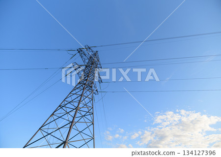 An Electricity Tower Stands Tall Against a Bright Blue Sky Filled with Cloud Patterns 134127396