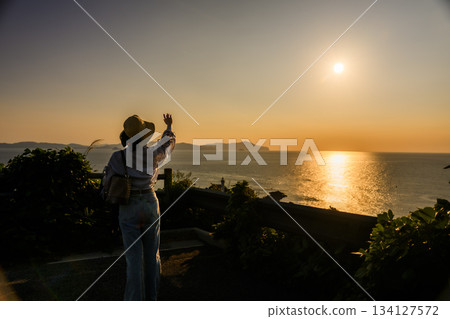 Sunset and woman at the seaside Sunset and woman at the seaside 134127572