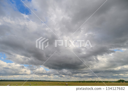 A Dramatic Cloud Formation Casts Shadows Over a Serene and Picturesque Landscape Scene 134127682