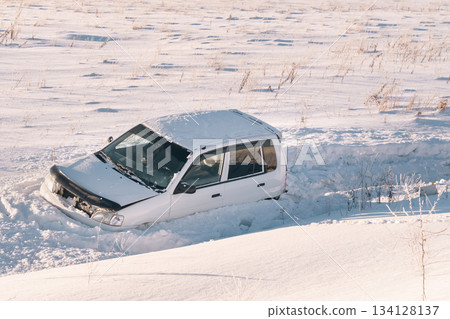 The car flew off the highway into the snow due to ice and drove into a ditch in a snowy field at high speed accident in winter. High quality photo The car flew off the highway into the snow due to ice and drove into a ditch in a snowy field at high speed accident in winter. High quality photo 134128137