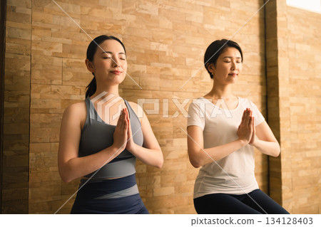 Two young women doing hot yoga. Beauty image. 134128403