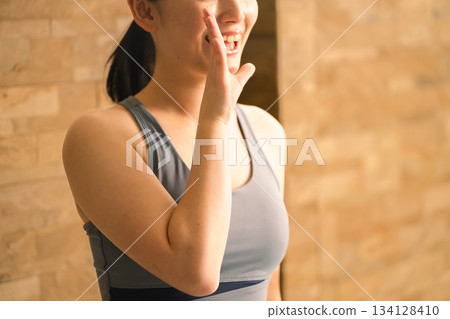 A young woman in yoga wear calling out to others - Beauty image 134128410