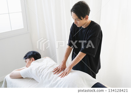 年輕人接受脊椎按摩師的按摩 134128421
