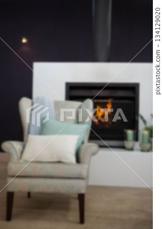 Cushions on sofa against fireplace 134129020