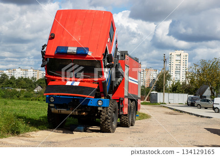 Municipal fire service vehicle positioned on road amid residential surroundings with active status 134129165