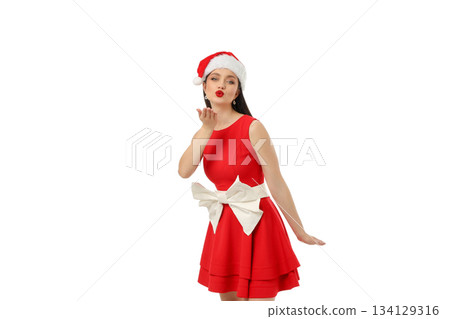 Woman in red dress and Christmas hat blows kiss, isolated, PNG 134129316