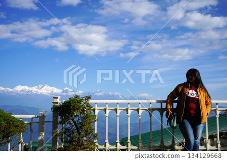 Woman Poses on Terrace Against Backdrop of Kanchenjunga Range from Darjeeling View Point 134129668