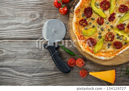 Pizza on by cutter on wooden table Pizza on by cutter on wooden table 134129727