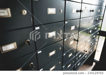 Depicting flat design dark-gray safe deposit box grid glowing under daylight window, keys dangling Depicting flat design dark-gray safe deposit box grid glowing under daylight window, keys dangling 134129783