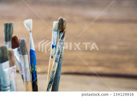 Close-up of paintbrushes on wooden table Close-up of paintbrushes on wooden table 134129916