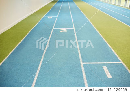 Blue track lanes are extending into perspective in flat design with green turf, white wall, windows Blue track lanes are extending into perspective in flat design with green turf, white wall, windows 134129939