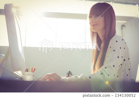 Beautiful woman working on desktop pc Beautiful woman working on desktop pc 134130052