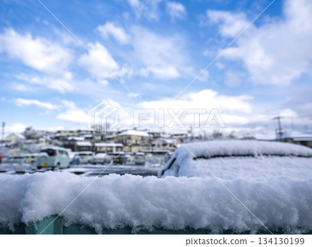 A residential area in winter with fresh snow piled up on the fence and a blue sky A residential area in winter with fresh snow piled up on the fence and a blue sky 134130199