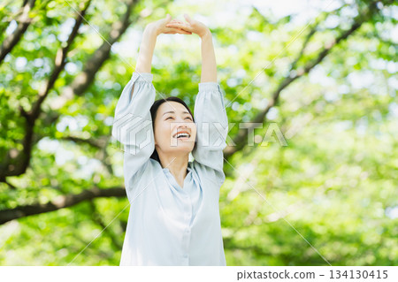 年輕女子在樹下伸展身體 生活方式圖像 134130415