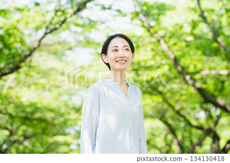 一位年輕女子抬頭仰望綠樹成蔭的街道生活方式圖片 134130418