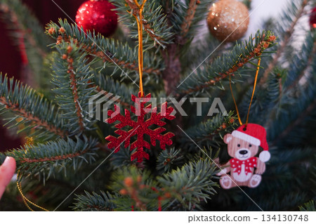 a Christmas tree decorated with a red glitter snowflake and a small teddy-bear ornament a Christmas tree decorated with a red glitter snowflake and a small teddy-bear ornament 134130748