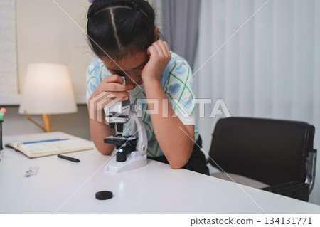 Elementary student practicing science skills using microscope during hands on learning activity Elementary student practicing science skills using microscope during hands on learning activity 134131771