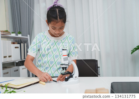 Elementary student exploring plant sample during science activity to build STEM understanding Elementary student exploring plant sample during science activity to build STEM understanding 134131775