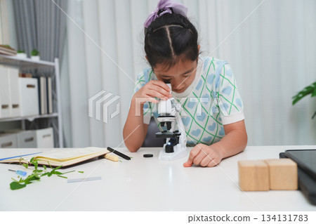 Young student exploring microscope highlighting STEM curiosity and scientific learning skills 134131783