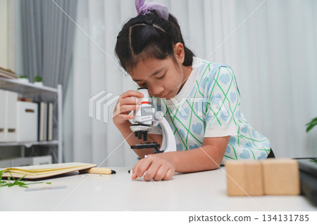 Young student exploring microscope highlighting STEM curiosity and scientific learning skills Young student exploring microscope highlighting STEM curiosity and scientific learning skills 134131785