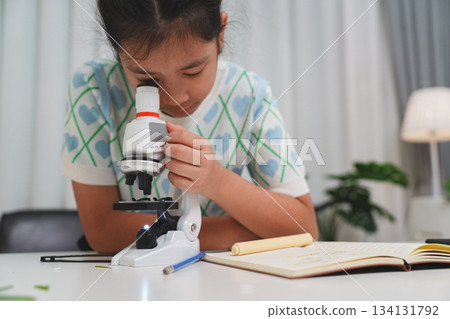 Young student exploring microscope highlighting STEM curiosity and scientific learning skills Young student exploring microscope highlighting STEM curiosity and scientific learning skills 134131792