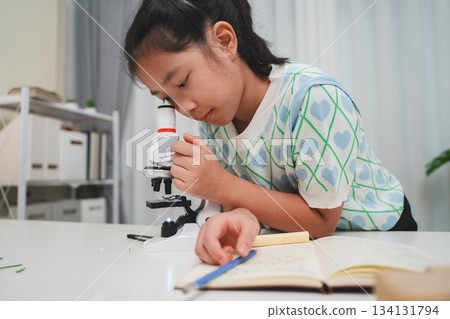 Young student exploring microscope highlighting STEM curiosity and scientific learning skills Young student exploring microscope highlighting STEM curiosity and scientific learning skills 134131794