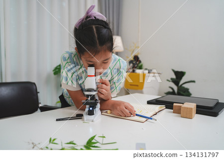 Elementary student practicing science skills using microscope during hands on learning activity Elementary student practicing science skills using microscope during hands on learning activity 134131797