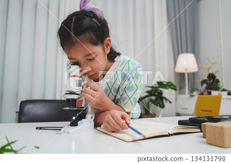Young student exploring microscope highlighting STEM curiosity and scientific learning skills 134131798