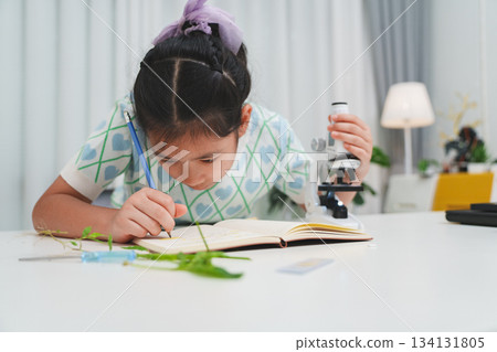 Elementary School Girl Taking Notes Science Experiment Microscope STEM Research Elementary School Girl Taking Notes Science Experiment Microscope STEM Research 134131805