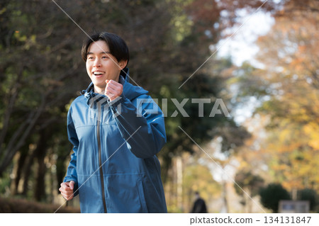 Close-up of a young man in his 20s doing sports running in the park in autumn and winter Close-up of a young man in his 20s doing sports running in the park in autumn and winter 134131847