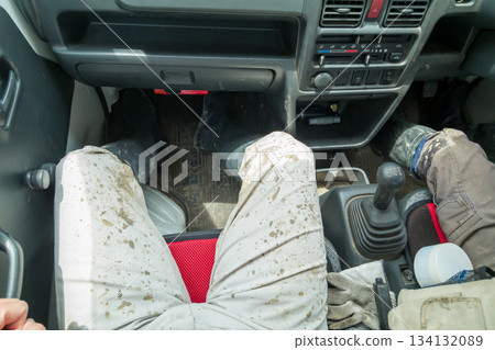 A rice farmer gets into a light truck in his soiled work clothes after planting rice. 134132089