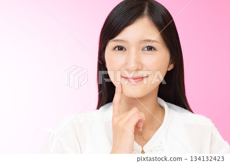 一位女子輕輕撫摸著自己的臉頰 一位女子輕輕撫摸著自己的臉頰 134132423