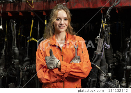 Female technician worker working in garage scrap yard old car part workshop warehouse. 134132542