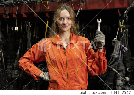 Female technician worker working in garage scrap yard old car part workshop warehouse. Female technician worker working in garage scrap yard old car part workshop warehouse. 134132547