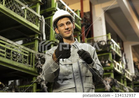 Technician worker working and smile to the camera in garage scrap yard car workshop warehouse. Technician worker working and smile to the camera in garage scrap yard car workshop warehouse. 134132937