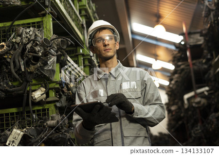 Technician worker working and checking in garage scrap yard car workshop warehouse. Technician worker working and checking in garage scrap yard car workshop warehouse. 134133107